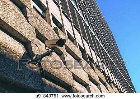 Stock Image - CCTV camera for surveillance on modern building facade.. Fotosearch