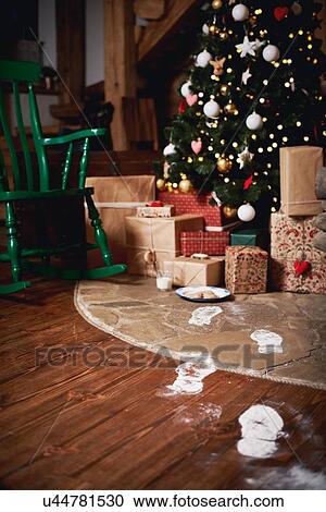 Christmas tree surrounded by presents, Santa's footprints leading towards tree View Large Photo Image Stock Image - Christmas tree surrounded by presents, Santa's footprints leading towards tree. Fotosearch