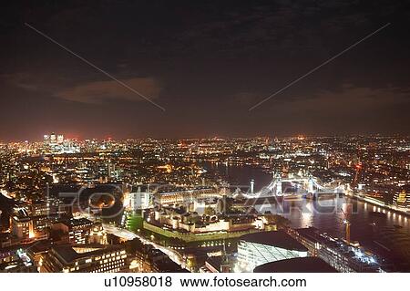 Stock Photo - Cityscape of London and river Thames illuminated at night, United Kingdom, Europe. Fotosearch