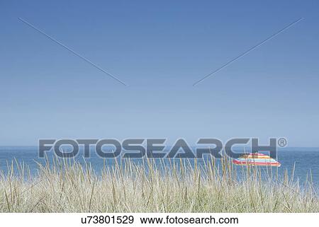 Stock Photo - Clear sky above beach umbrella in beach. Fotosearch