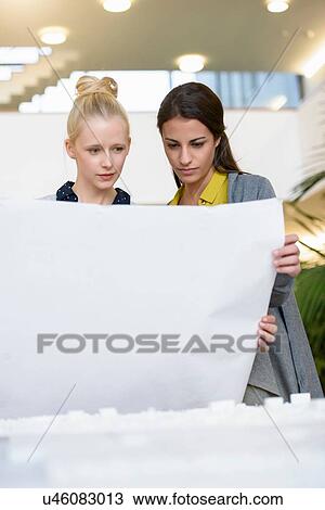 Colleagues discussing town planning drawings in office View Large Photo Image Stock Image - Colleagues discussing town planning drawings in office. Fotosearch