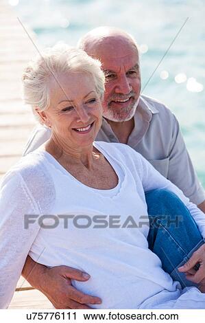 Couple enjoying seaside View Large Photo Image Stock Image - Couple enjoying seaside. Fotosearch