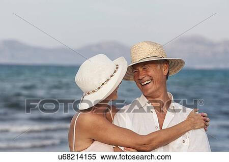 Stock Photography - Couple hugging on beach, Palma de Mallorca, Spain. Fotosearch