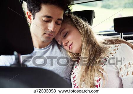 Stock Photo - Couple in backseat of car sleeping. Fotosearch