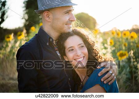 Couple in field of sunflowers, hugging View Large Photo Image Stock Photo - Couple in field of sunflowers, hugging. Fotosearch