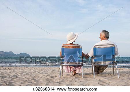 Picture - Couple on deckchairs on beach, Palma de Mallorca, Spain. Fotosearch