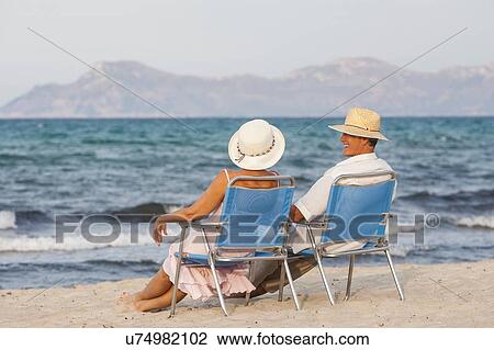 Couple on deckchairs on beach, Palma de Mallorca, Spain View Large Photo Image Stock Image - Couple on deckchairs on beach, Palma de Mallorca, Spain. Fotosearch