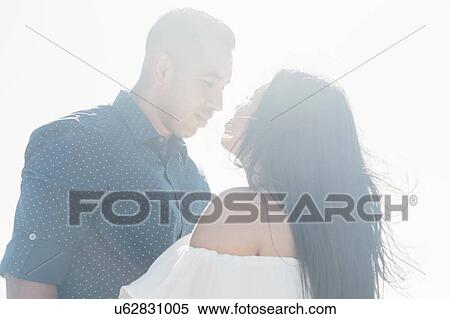 Stock Photography - Couple outdoors, face to face, gazing into each others eyes. Fotosearch