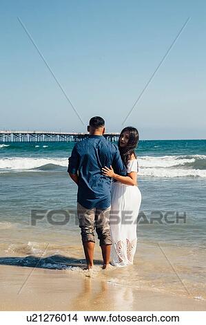 Couple standing on beach, rear view, Seal Beach, California, USA View Large Photo Image Picture - Couple standing on beach, rear view, Seal Beach, California, USA. Fotosearch