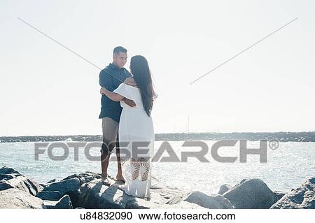 Couple standing on coastal rock, face to face, Seal Beach, California, USA View Large Photo Image Stock Image - Couple standing on coastal rock, face to face, Seal Beach, California, USA. Fotosearch