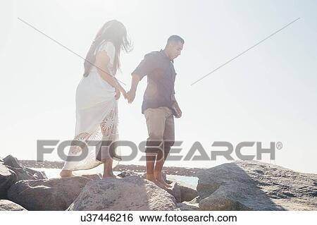 Couple standing on coastal rock, low angle view, Seal Beach, California, USA View Large Photo Image Stock Photograph - Couple standing on coastal rock, low angle view, Seal Beach, California, USA. Fotosearch