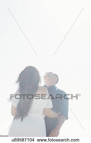 Picture - Couple standing outdoors, face to face, laughing. Fotosearch
