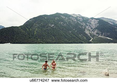 Stock Photo - Couple waist deep in water, Achensee, Innsbruck, Tirol, Austria, Europe. Fotosearch