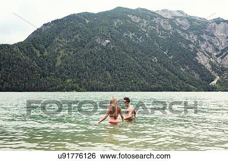 Stock Photograph - Couple waist deep in water, Achensee, Innsbruck, Tirol, Austria, Europe. Fotosearch