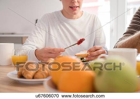 Cropped shot of young woman and boyfriend having croissants at breakfast table View Large Photo Image Stock Image - Cropped shot of young woman and boyfriend having croissants at breakfast table. Fotosearch