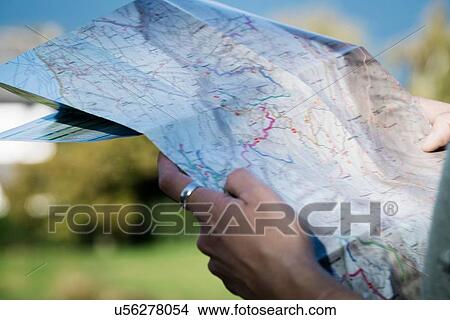 Cropped view of woman looking at folding map View Large Photo Image Picture - Cropped view of woman looking at folding map. Fotosearch