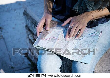 Cropped view of woman looking at folding map View Large Photo Image Picture - Cropped view of woman looking at folding map. Fotosearch