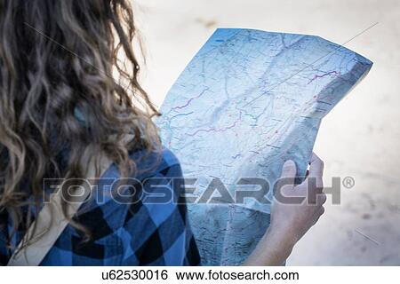 Cropped view of woman looking at folding map View Large Photo Image Stock Photograph - Cropped view of woman looking at folding map. Fotosearch