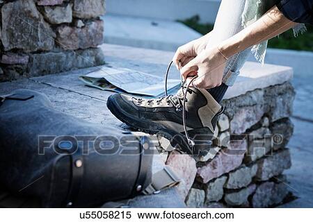 Cropped view of woman tying shoelace on walking boot View Large Photo Image Stock Photography - Cropped view of woman tying shoelace on walking boot. Fotosearch
