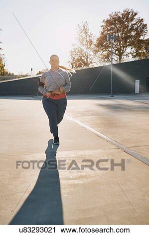Curvaceous young female runner running in sunlight View Large Photo Image Stock Image - Curvaceous young female runner running in sunlight. Fotosearch