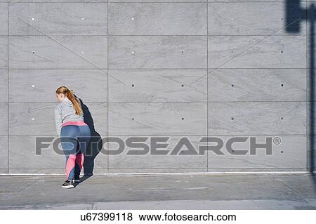 Curvaceous young woman training, doing wall push ups View Large Photo Image Stock Photo - Curvaceous young woman training, doing wall push ups. Fotosearch