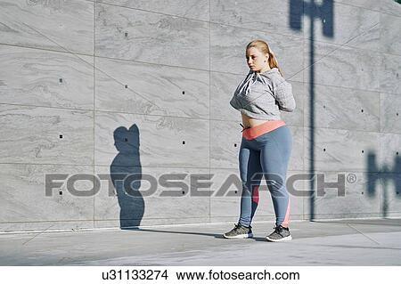 Curvaceous young woman training, stretching arms View Large Photo Image Picture - Curvaceous young woman training, stretching arms. Fotosearch