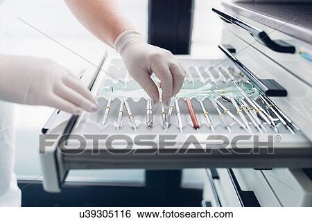 Stock Photograph - Dental nurse preparing dentistry equipment, close-up. Fotosearch
