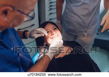 Dentist and dental nurse carrying out dental procedure on female patient View Large Photo Image Stock Photography - Dentist and dental nurse carrying out dental procedure on female patient. Fotosearch