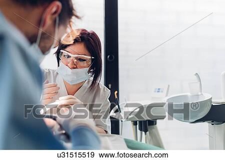 Dentist and dental nurse, examining patient's mouth View Large Photo Image Stock Photo - Dentist and dental nurse, examining patient's mouth. Fotosearch