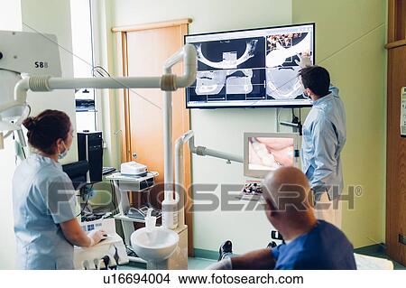 Dentist and dental nurse looking at dental x-rays View Large Photo Image Picture - Dentist and dental nurse looking at dental x-rays. Fotosearch