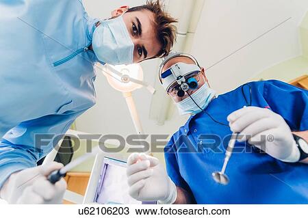 Dentist and dental nurse treating patient, personal persepctive View Large Photo Image Stock Image - Dentist and dental nurse treating patient, personal persepctive. Fotosearch