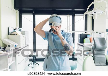 Dentist putting on dental binocular loupe View Large Photo Image Stock Photograph - Dentist putting on dental binocular loupe. Fotosearch