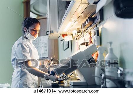 Dentist using dental equipment in dentist office View Large Photo Image Picture - Dentist using dental equipment in dentist office. Fotosearch