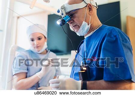 Stock Image - Dentist wearing dental binocular loupes. Fotosearch