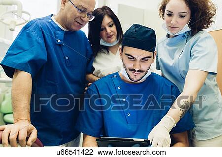Dentists in dentist office looking at digital tablet View Large Photo Image Stock Image - Dentists in dentist office looking at digital tablet. Fotosearch