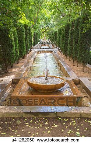 Stock Image - Diminishing perspective of fountain in garden, Palma de Mallorca, Majorca, Balearic Islands, Spain, Europe. Fotosearch