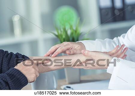 Stock Photography - Doctor examining woman's arm.. Fotosearch