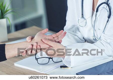 Doctor examining woman's wrist. View Large Photo Image Stock Image - Doctor examining woman's wrist.. Fotosearch