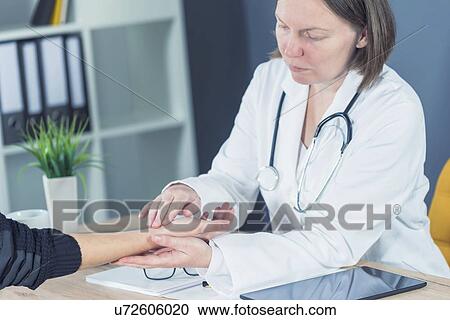 Doctor examining woman's wrist. View Large Photo Image Stock Image - Doctor examining woman's wrist.. Fotosearch