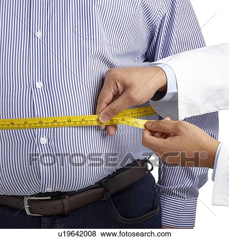 Doctor measuring an overweight man's waist using a tape measure. View Large Photo Image Stock Photo - Doctor measuring an overweight man's waist using a tape measure.. Fotosearch