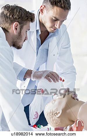 Picture - Doctor practising bag-valve-mask ventilation on a training dummy.. Fotosearch