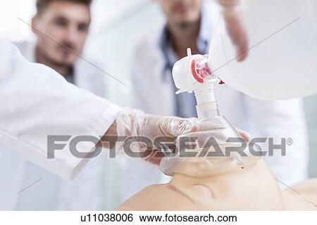 Stock Photograph - Doctor practising bag-valve-mask ventilation on a training dummy.. Fotosearch