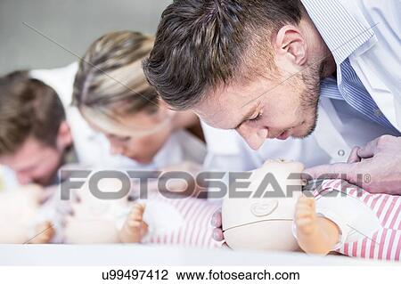 Doctor practising infant CPR on training dummies. View Large Photo Image Stock Image - Doctor practising infant CPR on training dummies.. Fotosearch