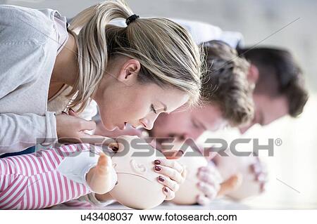 Stock Photo - Doctor practising infant CPR on training dummies.. Fotosearch