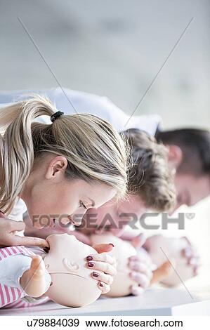 Stock Photo - Doctor practising infant CPR on training dummies.. Fotosearch