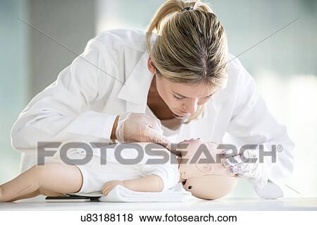 Doctor practising infant CPR on training dummies. View Large Photo Image Stock Photo - Doctor practising infant CPR on training dummies.. Fotosearch