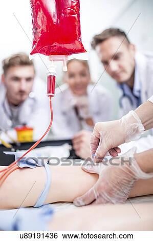 Doctor practising inserting an IV (intravenous) line on a training dummy. View Large Photo Image Stock Photograph - Doctor practising inserting an IV (intravenous) line on a training dummy.. Fotosearch
