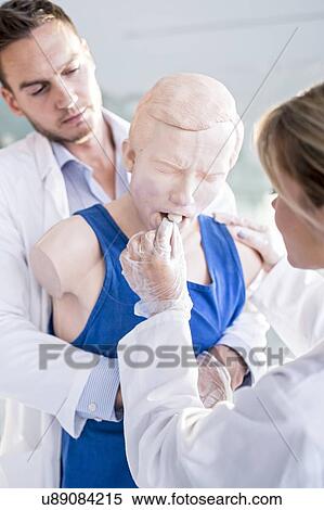 Doctor practising the Heimlich manoeuvre on a training dummy. View Large Photo Image Stock Photography - Doctor practising the Heimlich manoeuvre on a training dummy.. Fotosearch