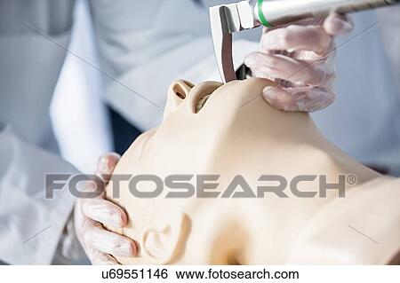 Stock Photograph - Doctor practising tracheal intubation on a training dummy.. Fotosearch