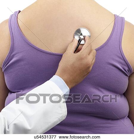 Stock Photo - Doctor using stethoscope to examine overweight woman.. Fotosearch